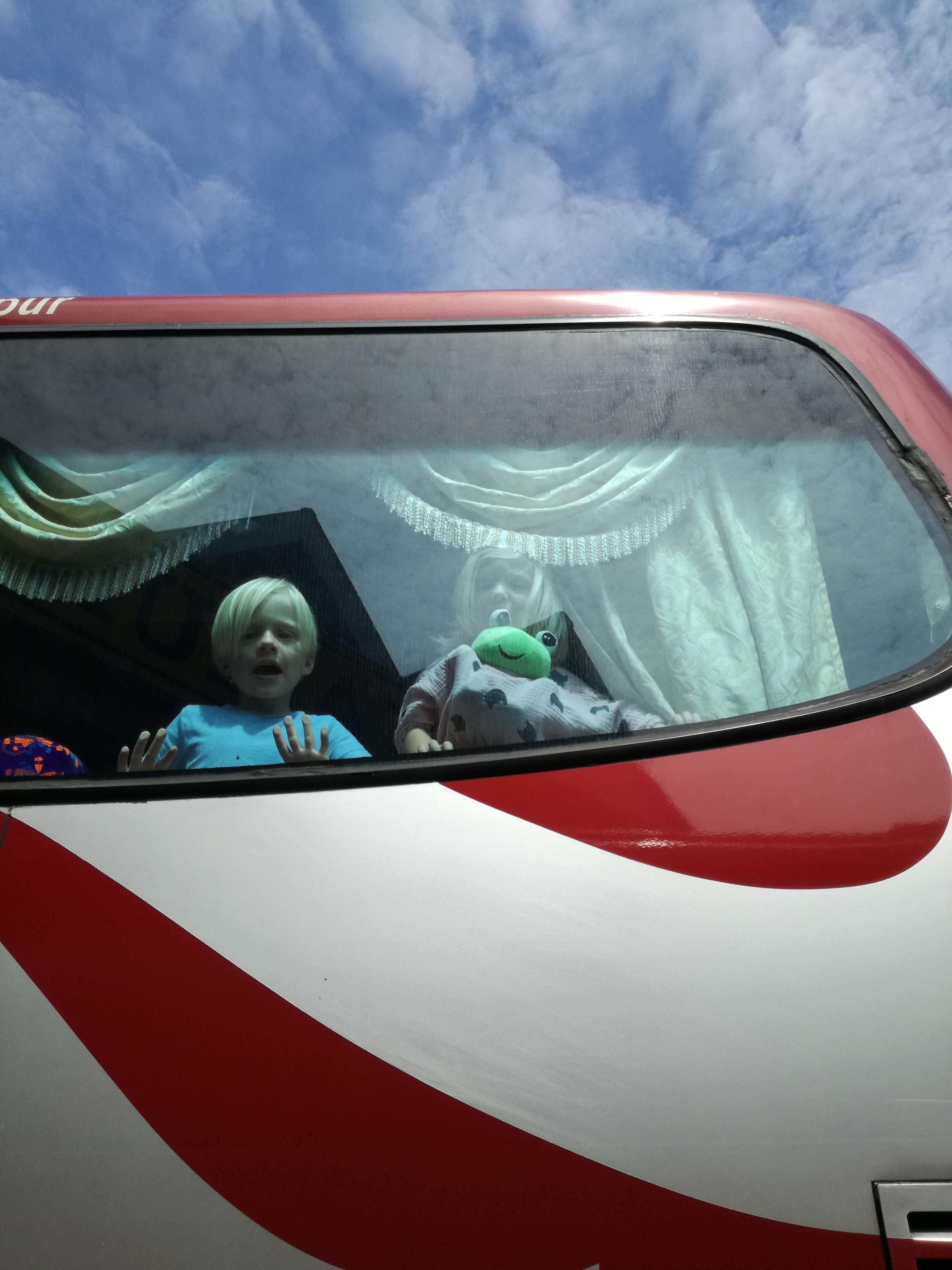 Kids looking out of bus window